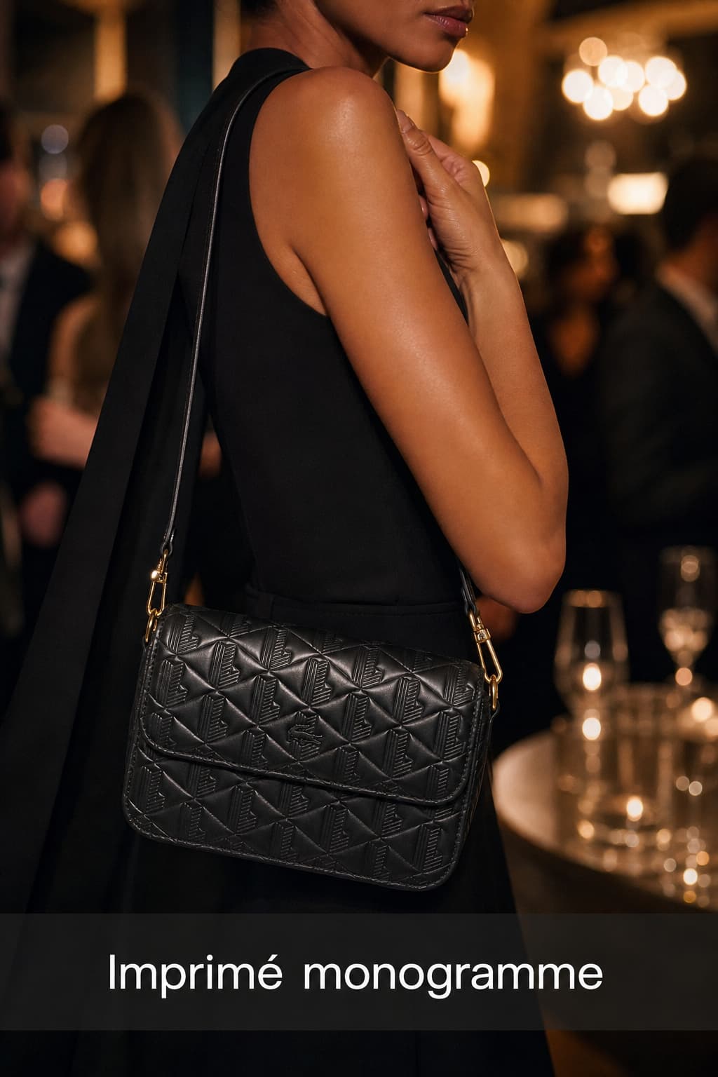 Sac pochette Lacoste en cuir monogrammé porté en bandoulière par une personne stylée lors d