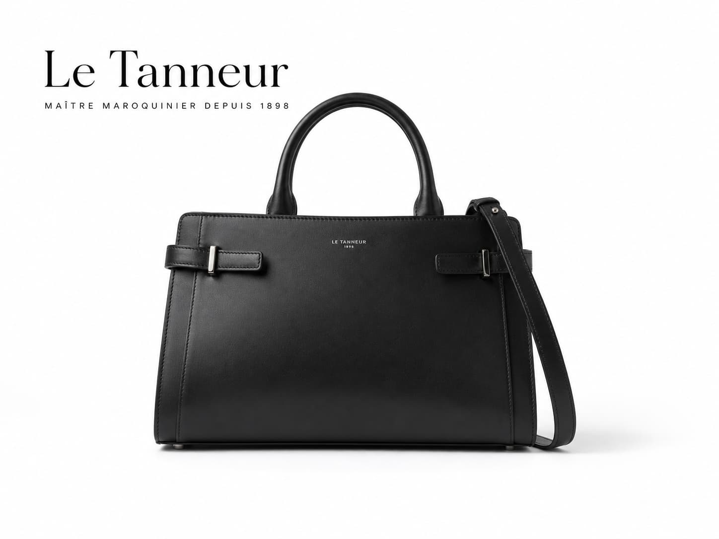 Sac à main Le Tanneur Émilie en cuir noir, avec fermeture supérieure courbée et logo discret, sur fond blanc, avec texte superposé « Le Tanneur ».