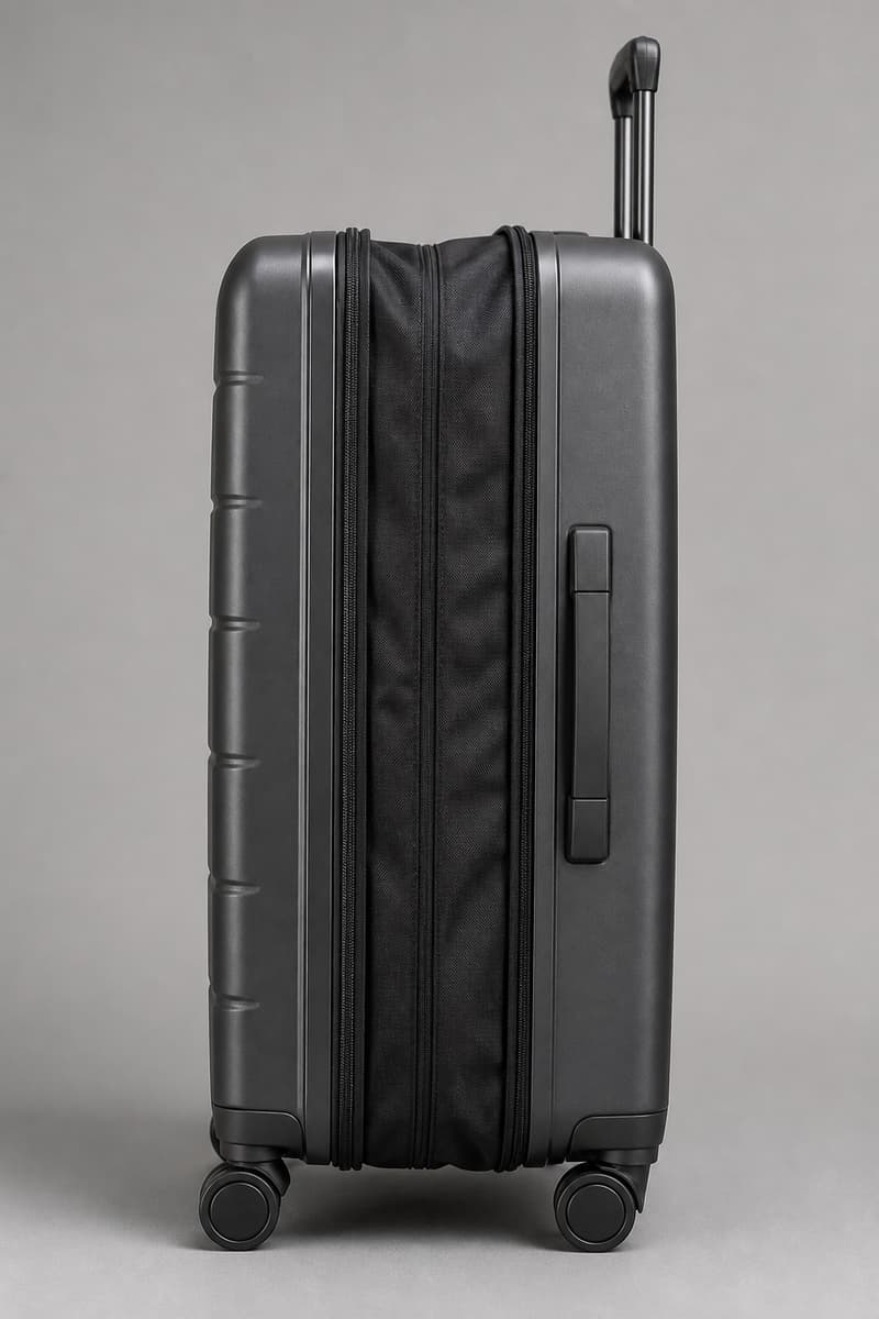 Valise rigide vue de côté avec soufflet extensible déployé et fermeture éclair périphérique visible.